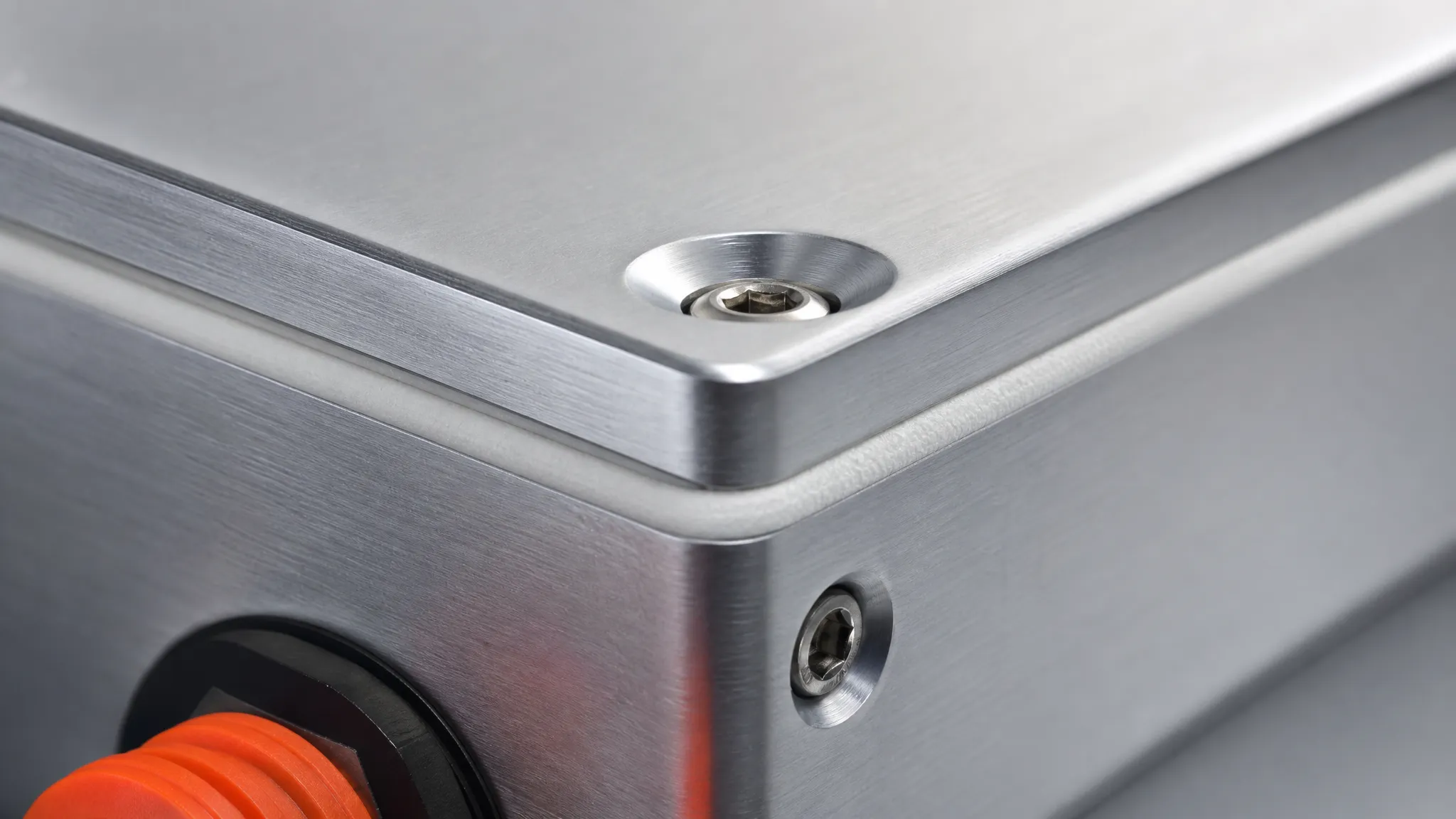 A closed-cell silicone foam gasket compressed along the joint between an aluminium enclosure lid and base