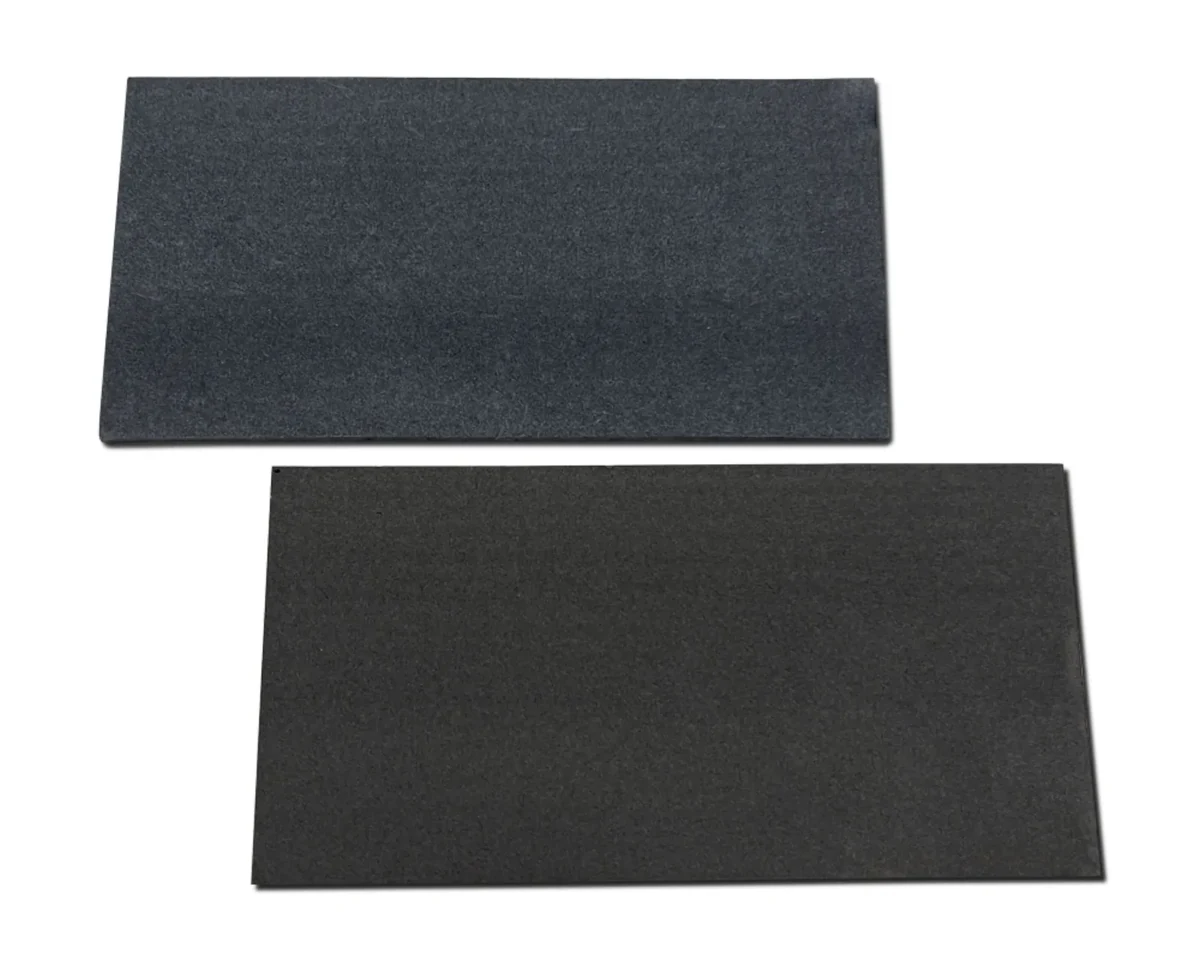 A real ZIITEK TIR 700 carbon fiber thermal pad: two thin dark grey sheets supplied as flat plates for space-constrained devices